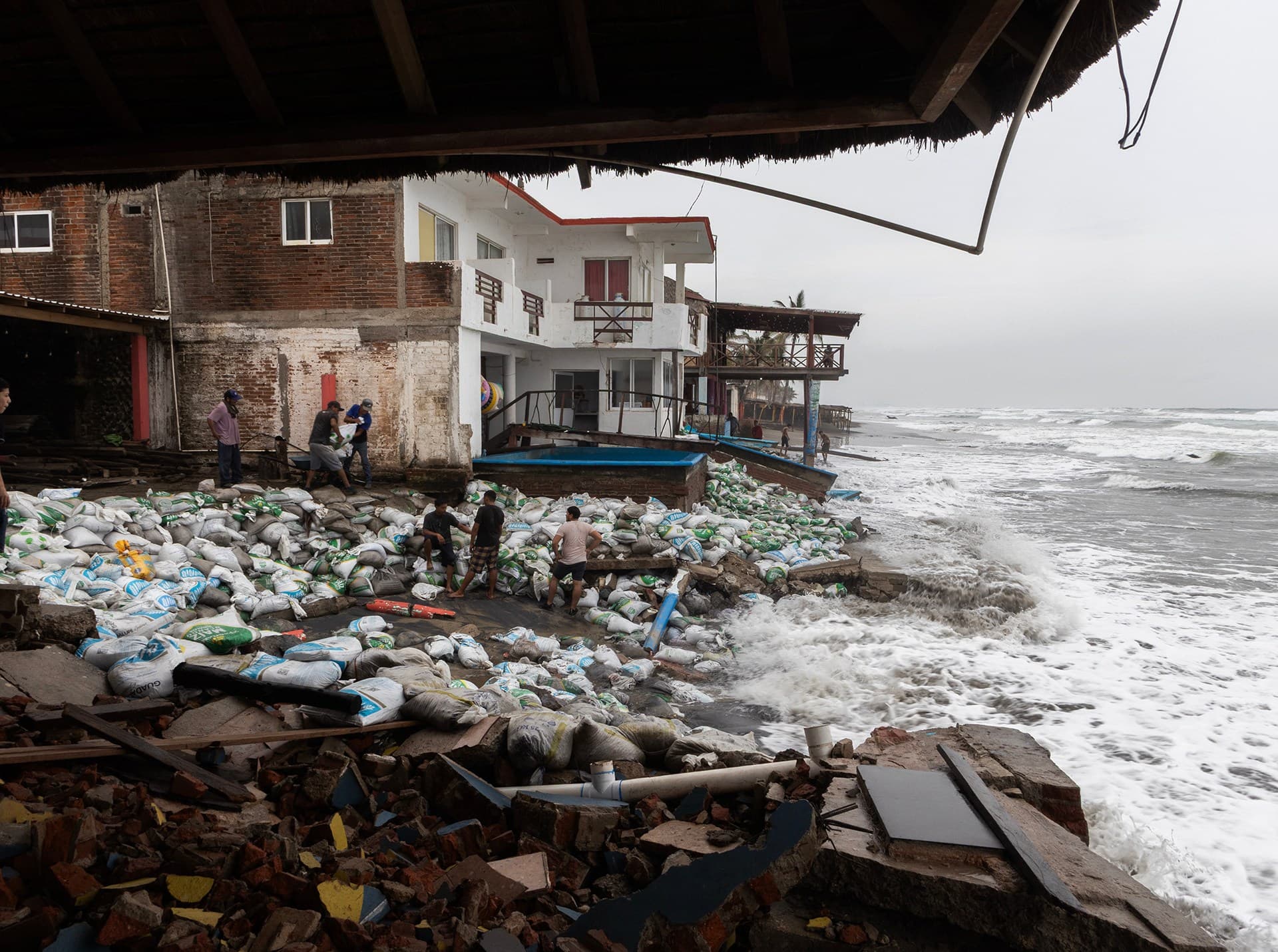 Mexican residents place sandbags against strong waves generated by Hurricane Polo at Playa Azul in Michoacan, September 23, 2026.