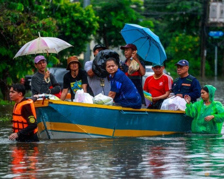 People ride in a boat along a flooded street in Bangkok, Thailand, on Sep 26, 2026.