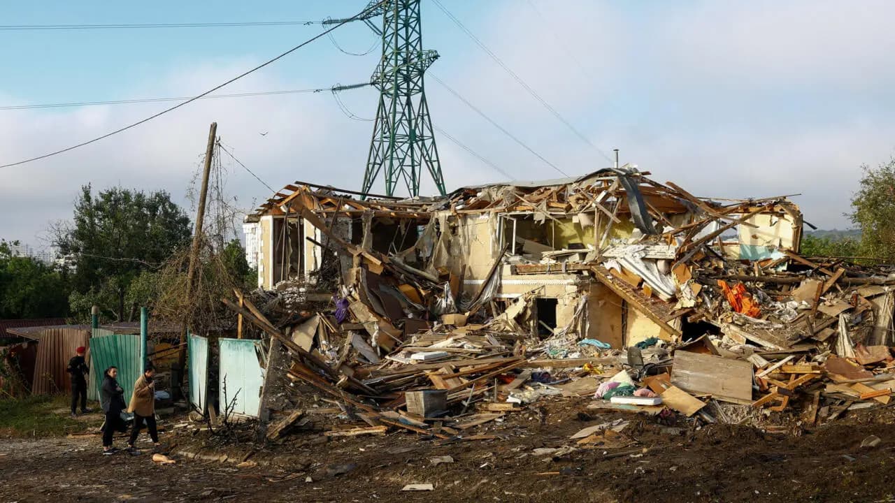 A police officer and residents stand in front of a home that was heavily damaged during a Russian missile strike in the town of Vyshhorod, Kyiv region, Ukraine, September 30, 2026.