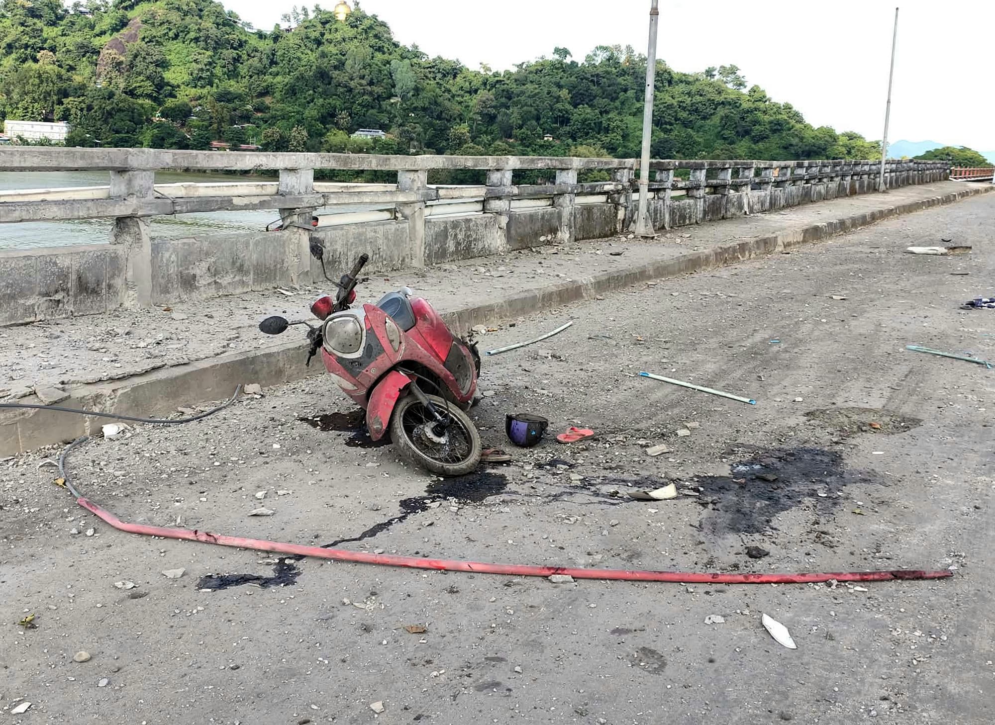 A damaged motorcycle is seen on a bridge after a market in an adjacent area was allegedly hit by the military.