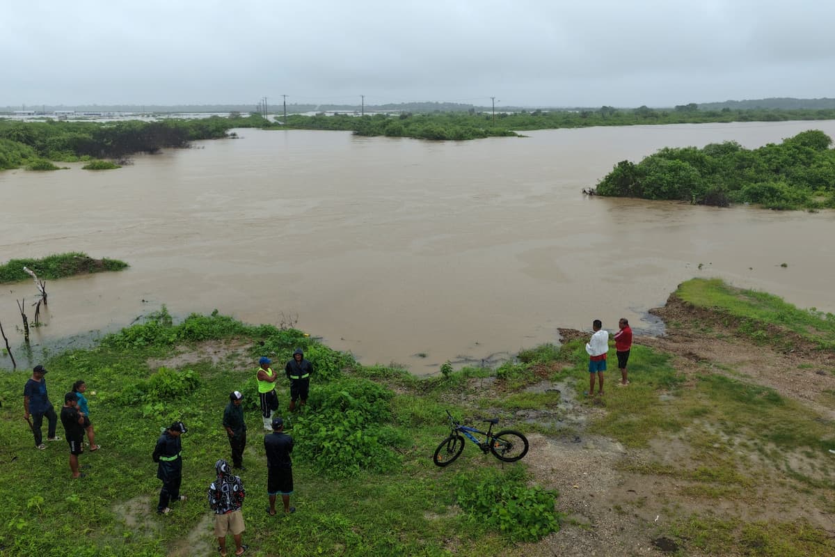 People watch floodwaters at Chanduy, Santa Elena, on Ecuador’s coast.