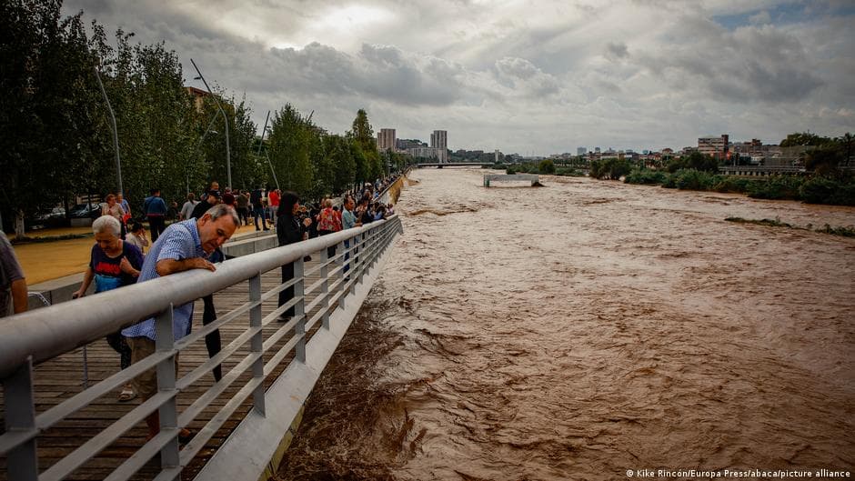People watch the swollen Besòs River after it exceeded its danger level following torrential rain near Barcelona.