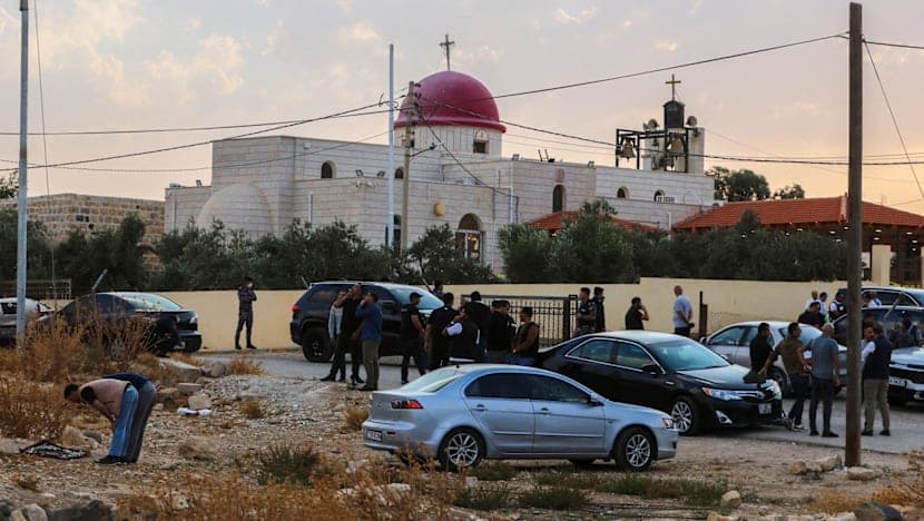 People and security forces gather outside the Greek Orthodox church in Hamoud, in Jordan’s Karak governorate, after the shooting on 23 October 2026.